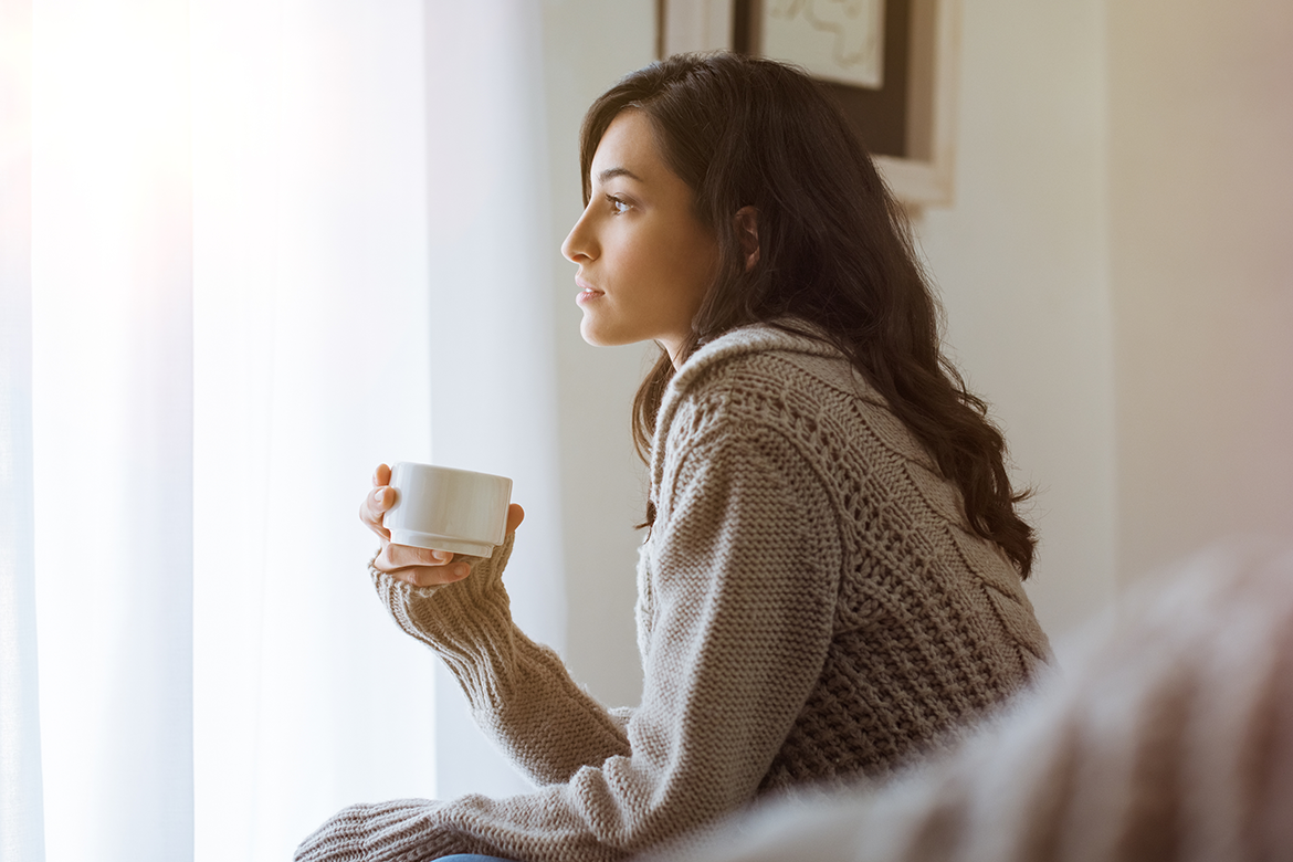 Woman drinking coffee on gloomy winter day